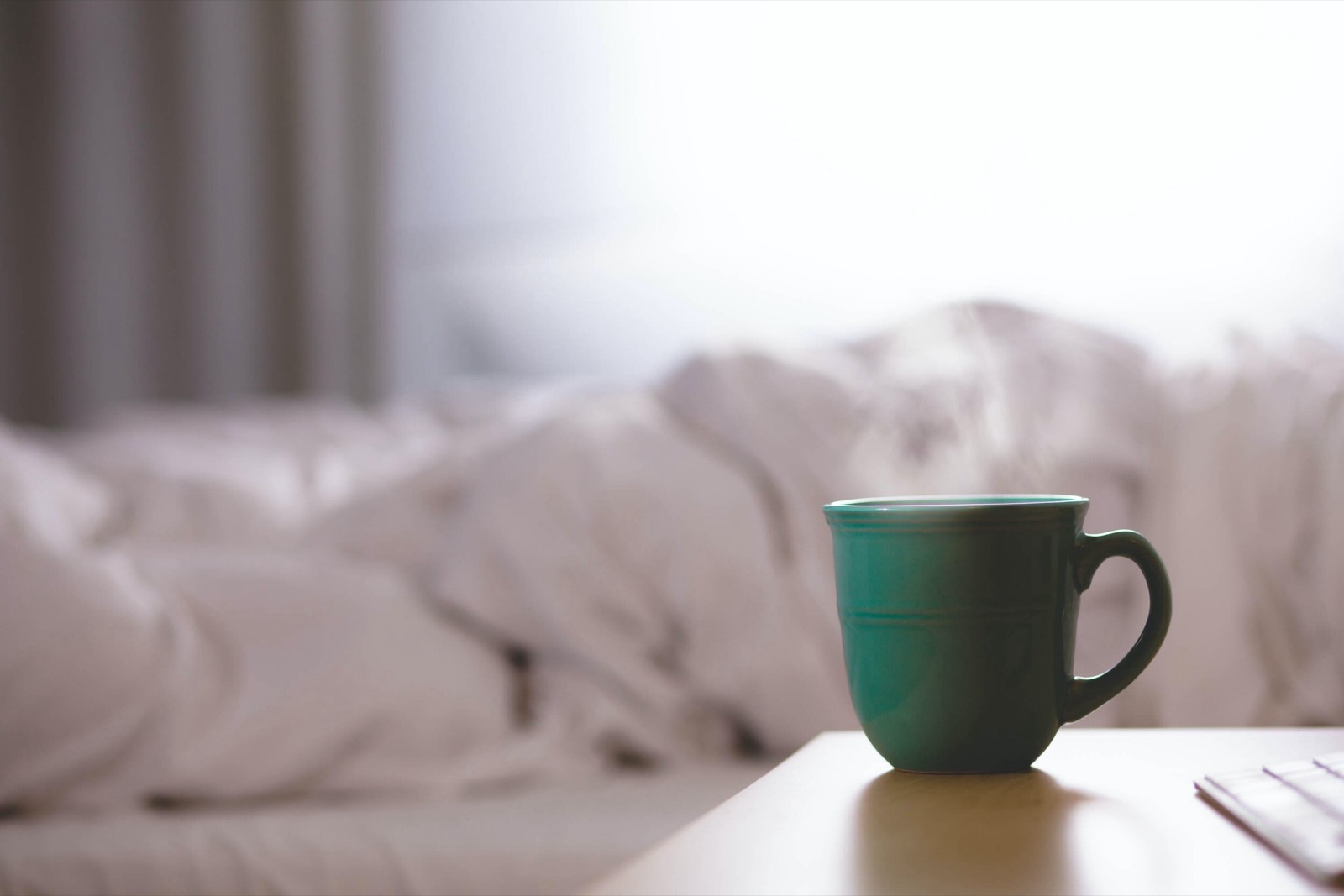 Kranus Health: Gründe Kaffeetasse dampfend vor Bett